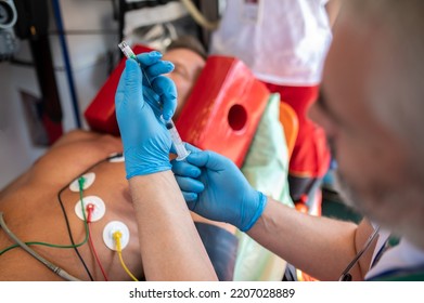 Ambulance doctor preparing to administer an injection to a patient - Powered by Shutterstock