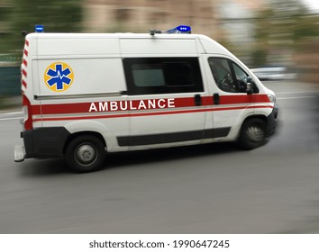 An Ambulance Is Driving Down The Street