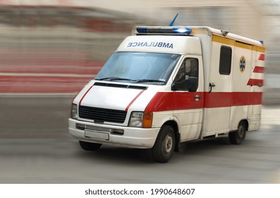 An Ambulance Is Driving Down The Street