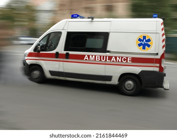 An Ambulance Is Driving Down The Street