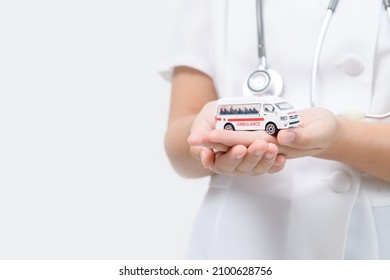 Ambulance Model In Doctor Hand Isolated On White Background, Patient Transfer Service Or Insurance Concept