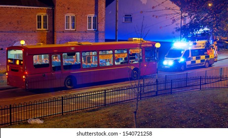 An Ambulance On A Signal Opposite A City Bus During A Night Course In Willenhall. October 24, UK 2019