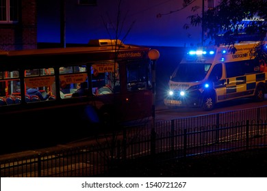 An Ambulance On A Signal Opposite A City Bus During A Night Course In Willenhall. October 24, UK 2019