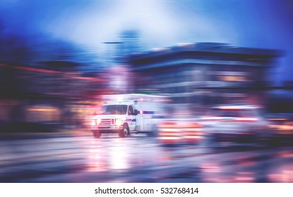 an ambulance racing through the rain on a stormy night with motion blur (NO SHARP FOCUS DUE TO RAIN) with reflections in the road 