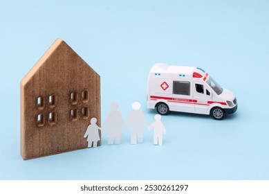 Ambulance toy, wooden house and paper family cutouts on blue background , emergency services and family care concept - Powered by Shutterstock