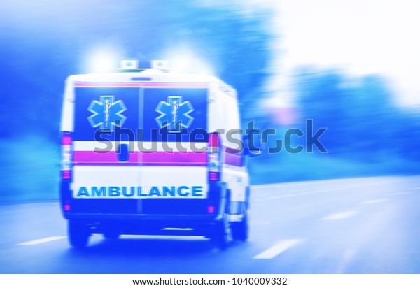 Ambulance van on highway, emergency lights,\
blurred motion