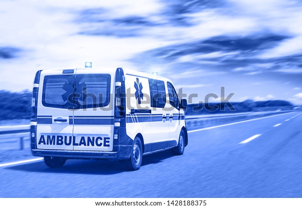 Ambulance van on\
highway with flashing\
lights