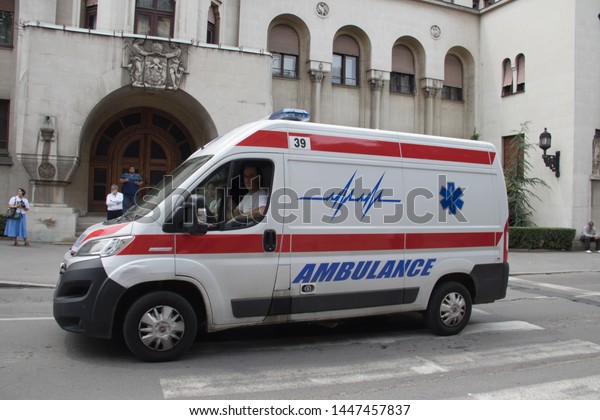 Ambulance\
vehicle on the street, with Police in background, securing public\
event, Saint day of Belgrade city, 06 June\
2019