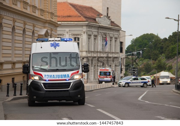 Ambulance\
vehicle on the street, with Police in background, securing public\
event, Saint day of Belgrade city, 06 June\
2019