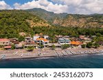 Amed, Bali: Aerial view of the Amed village with its beach lined with traditional fishing boat, the Jukung, and hotel and guesthouse in Bali northeast coast in Indonesia