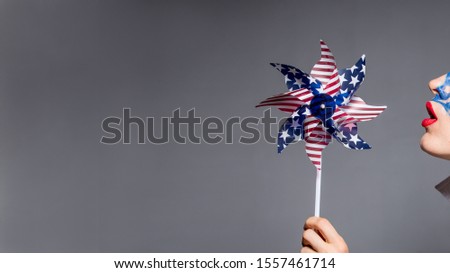 Amercian freedom concept, patriotic woman holding pinwheel with amercian flag