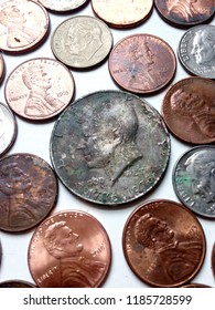 An American 50 Cent Piece, Some Pennies And Dimes On A White Background In A Collage. (USA)