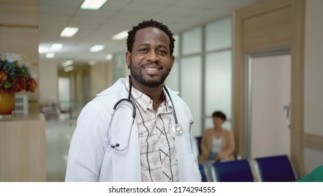 American - African Ethnicity Doctor Crossing His Arms In Hospital, Doctor Portrait With Blurred Hospital Ward Background.