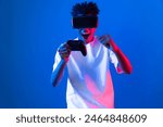 American African gaming player wearing VR controlling joystick hologram isolated blue pink neon lighting wall screen connect digital futuristic technology virtual reality metaverse world. Contrivance.