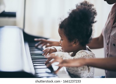 American African young pianist, teacher teaching girl kid student to play piano, Art of music education concept