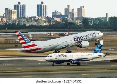 American Airlines Boeing 777 taking off from John F. Kennedy International Airport with the jetBlue Airbus A320 taxing behind it. Queens, New York, USA, October 2, 2019.