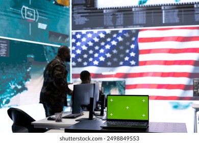 American army working in a command post with green screen, soldiers examining satellite imagery for clues regarding a national safety operation. US military control tower for surveillance.