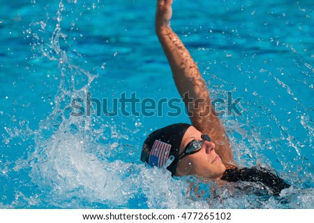 American back stroke swimmer. Focus set on head, hand in motion blur, polarizing filter used