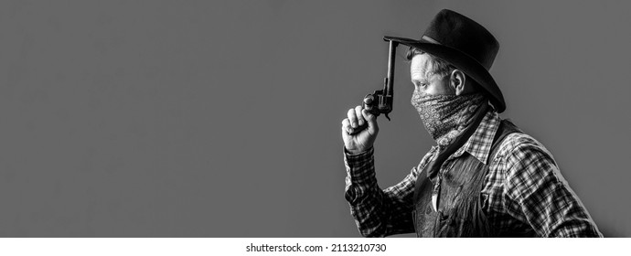 American bandit in mask, western man with hat. Portrait of cowboy in hat. Portrait of man wearing cowboy hat, gun. Portrait of a cowboy. West, guns. Black and white.