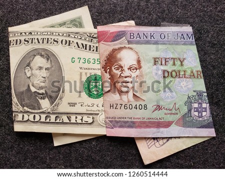 american banknote of five dollars and jamaican banknote of fifty dollars