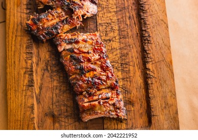 American Barbecue Meat. Delicious Bbq Ribs Cut On Wooden Desk. Grilled Ribeye Steak Meat . Griling Season Meat Serving, Closeup. Steakhouse Dinner.
