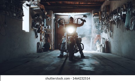 American biker with his motorcycle in the garage. cool and powerful chopper which the biker collected with his own hands - Powered by Shutterstock