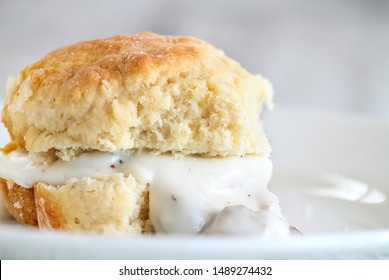 American biscuits from scratch served with thick white sausage gravy. Selective focus against white background. 