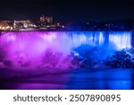 American and Bridal Veil Waterfalls. Blurred streams of Niagara Falls, illuminated in blue and purple in the evening. Canada. One of the world