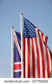 American and British national flags waving upon blue sky