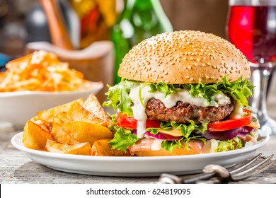 An American Burger With Fried Potatoes On The White Plate. 