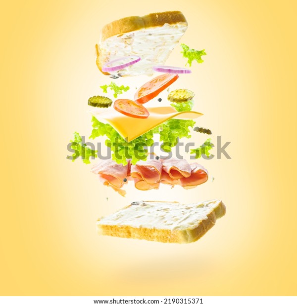 American burger with\
meat, cheese, vegetables and greens in a frozen flight on a yellow\
sunny background. Fast food, vitamins, calories. Restaurant, hotel,\
cafe, catering.