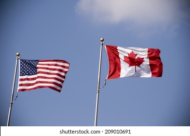 American and Canadian flags fly side by side