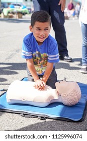 American Canyon, CA/USA- 03/25/2017: Child Practices Hands Only CPR At Fire & Rescue CPR Training Booth At Community Event.