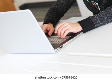 American Caucasian Male College Student Typing On Personal Laptop Computer Keypad Completing School Work Inside Of Modern Minimalist Dormitory Study Room