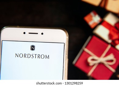 American Chain Of Luxury Jewelry Department Store Company Nordstrom Logo Is Seen On An Android Mobile Device With A Christmas Wrapped Gifts In The Background