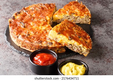 American Cheeseburger Pie With Ground Beef And Cheddar Cheese Close-up On A Slate Board On The Table. Horizontal
