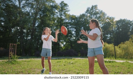 American children playing ball. American football sports concept. American football with children playing in a park. American football player and his children playing football in park lifestyle. - Powered by Shutterstock