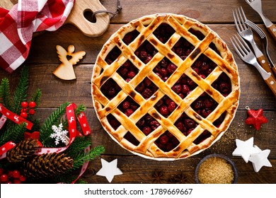 American Christmas Cherry Pie With Lattice And Xmas Decorations On Wooden Background

