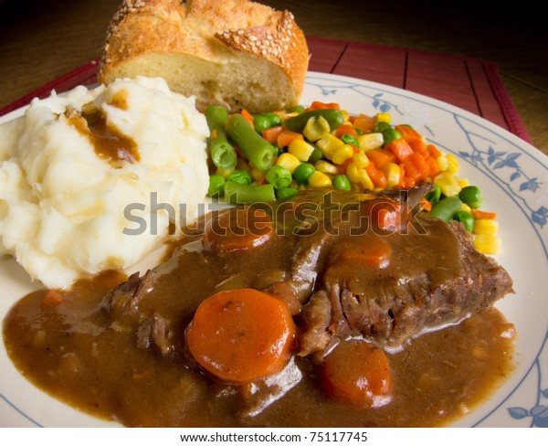 American comfort food; a heart dish of\
pot roast smothered in gravy, mashed potatoes and mixed vegetables.\
 This is a dish of real homecooked meat and\
potatoes.