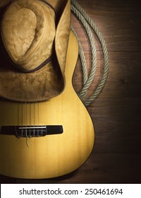 American Country music with guitar and cowboy hat on wood background