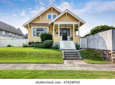 American craftsman home with yellow exterior paint and well kept front garden. Northwest, USA
