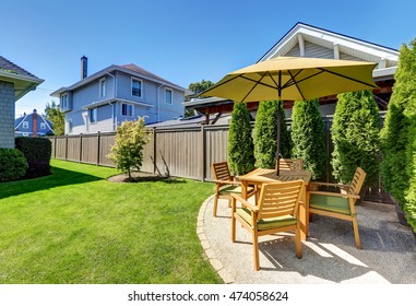 American Craftsman House Exterior. Small Patio Area With Wooden Table Set And Umbrella. Green Thuja Trees In Pots And Well Kept Lawn. Northwest, USA