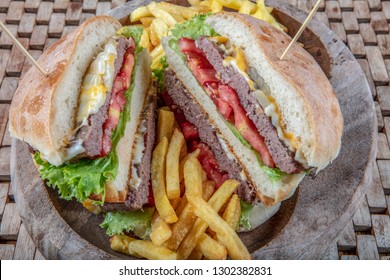 American cuisine concept. A juicy meat burger with a large klatta, tomato, cucumber, ketchup and salad. Cooking burgers at home. Background image for a menu in restaurants or cafes. copy space - Shutterstock ID 1302382831