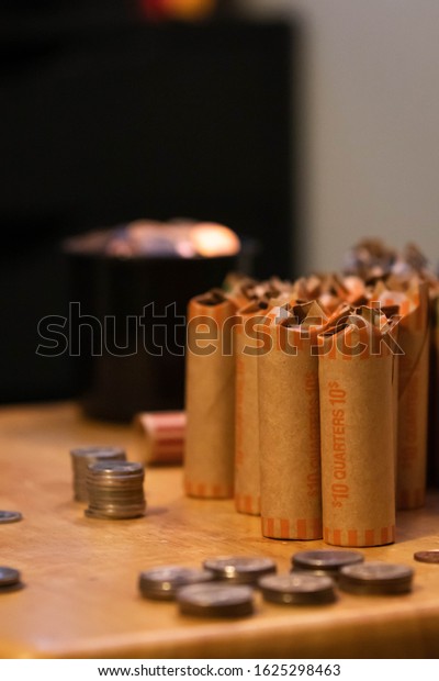 American currency coins rolled up into coin\
rollers. Savings being prepared for bank deposit. Quarters, dimes,\
nickles and pennies.\
Dollars.