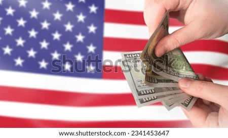 American currency. Dollars in hands. US money. Man counts money. US flag. Financial relations in America. USD payment. United states money. Paper banknotes of dollars. Currency USD.