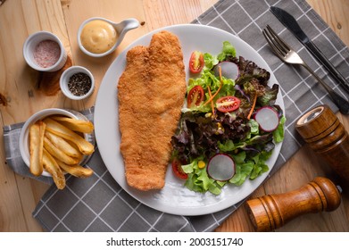 American Deep fried Pangasius dory fish fillet steak, chips and vegetables in the studio lighting