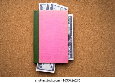 American Dollar Bills Embedded In An Old Book Against The Background Of A Cork Tree. Business, Finance.