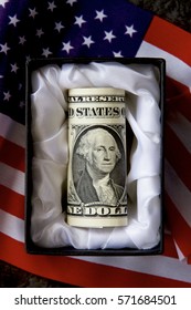 An American Dollar In A Casket With A Flag.