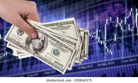American dollar in man's hand and stock market screen, money chart background