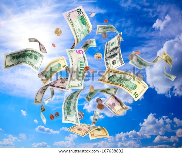 American dollars banknotes and coins falling from\
blue sky